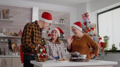 Family Celebrating Christmas, Exchanging Gifts in Kitchen