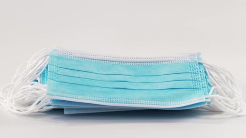 Medical Masks Fall on a White Surface in Slow Motion. A Stack of Medical Masks Falls on a Sterile