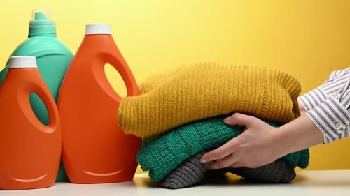 Bottles of Detergent and Stack of Sweaters