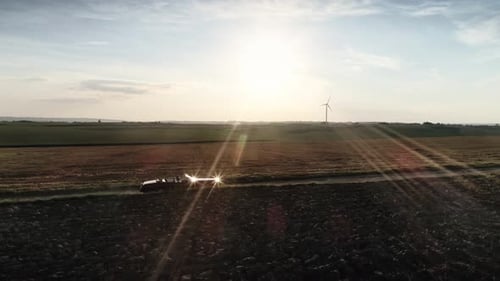 Red car drives down country road at a summer sunset. Shot with RED helium camera in 8K