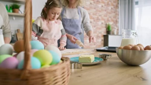 Tracking video of three generations of women preparing Easter cake