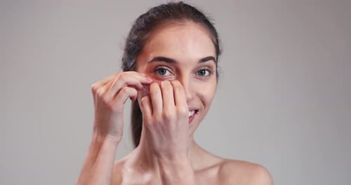 Woman Applying Cosmetic Eye Mask Close Up