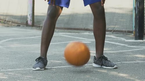 Sportlicher schwarzer Mann, der mit Ball Tricks macht, Basketball spielen, Aktiver Lebensstil