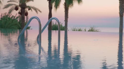 Outdoor swimming pool on resort, view at sunset