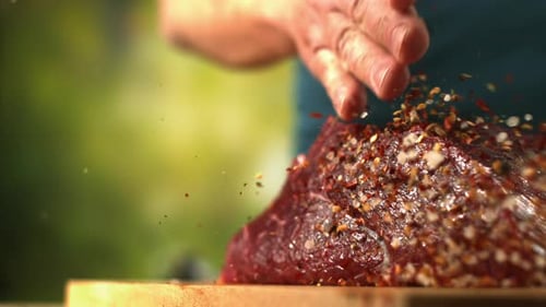 Seasoning Raw Red Meat with Spices Outdoors