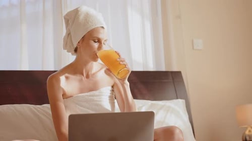 Woman Drinking Juice and Using Laptop at Hotel Room