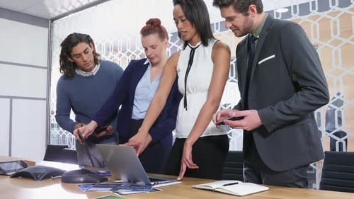 Gruppe von Führungskräften diskutiert über Laptop am Schreibtisch 4k