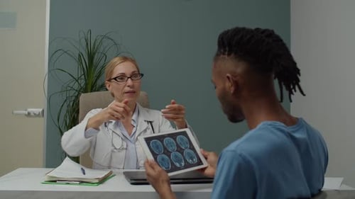 Woman Doctor Discusses Medical Scan With Patient