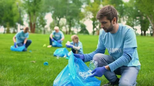 Man Volunteering Picking Up Trash in Park