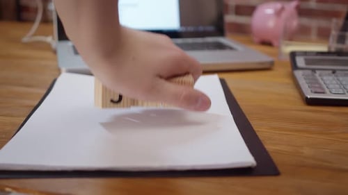 Holzwürfel mit der Aufschrift „New Job“ werden auf den Schreibtisch gelegt