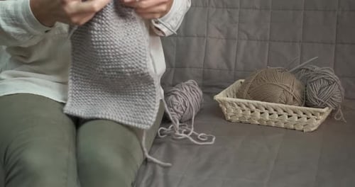 Woman Knitting Gray Fabric in Cozy Setting