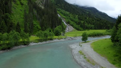 Aerial Motion Towards Mountain River and Waterfall in Pine Tree Forest