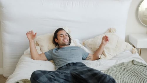 Man Relaxing on Bed in Bright Bedroom
