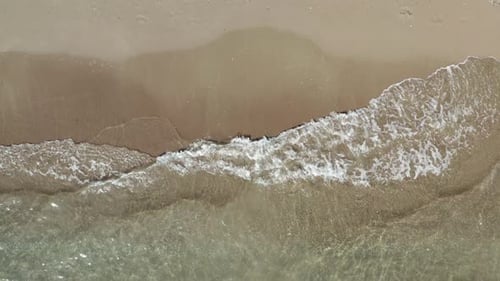 Waves Washing onto Sandy Beach from Above