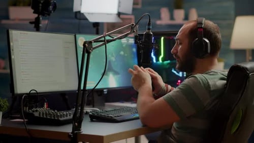 Young Adult Gamer Playing Video Game at Desk