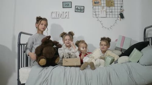 Children Playing With Gifts and Toys on Bed