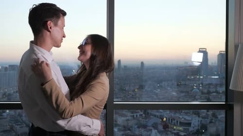 Couple, Man and Woman Are Dancing Near the Panoramic Window with City View.