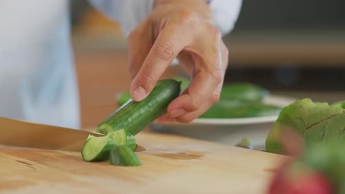 Close up shot of man cutting cucumber