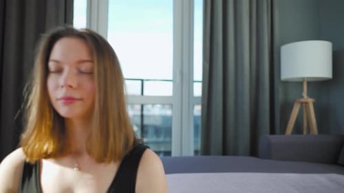 Young Woman Meditating in Living Room