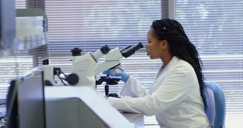 Scientist using microscope in laboratory