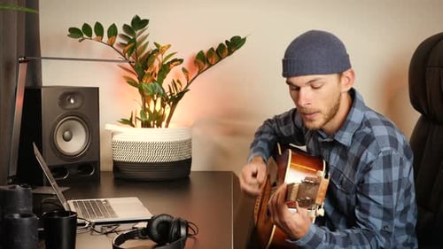 Man Playing Guitar in a Home Studio