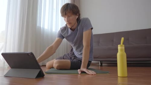 Man Using Tablet for Home Fitness Routine