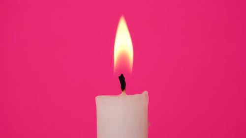 Flickering Candle Flame on Pink Background