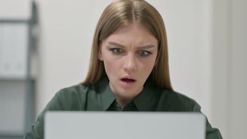 Young Woman Shocked and Disappointed by Laptop Content