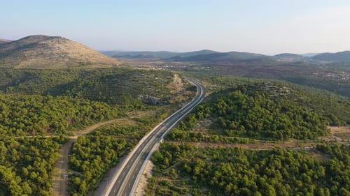 Aerial view on road. Highway through mountain valley. View from a drone.