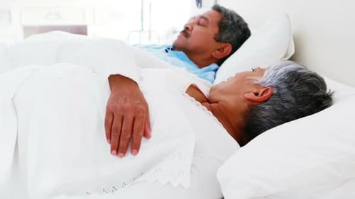 Senior woman getting disturbed with man snoring on bed 4k