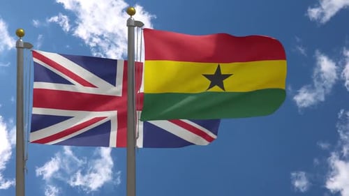 United Kingdom and Ghana Flags Waving on Flagpoles in Blue Sky