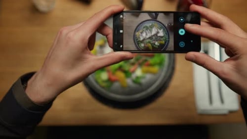 Man Taking Photos Dinner Using Phone at Restaurant Table