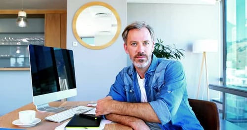 Man Smiling at His Desk in Modern Home Office