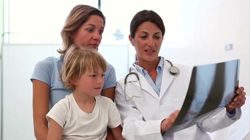 Doctor Reviewing X-Ray with Child and Mother