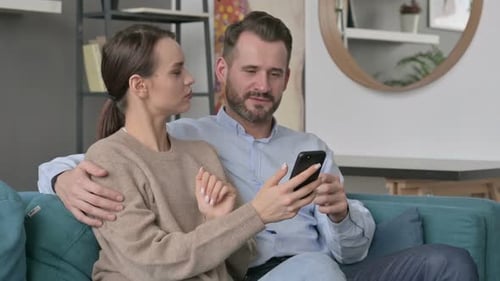 Affectionate Couple Relaxing and Using Smartphone Together