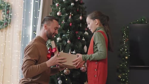 Affectionate Father Giving Christmas Present to Child