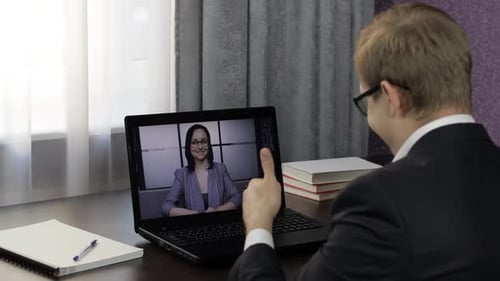 Man in Suit Talking on Laptop Video Call