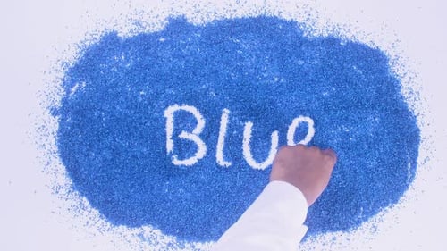 Hand Writing 'Blue' in Blue Grains