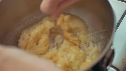Chefkoch püriert eine Banane in einer Rührschüssel, während er in der Küche Brot