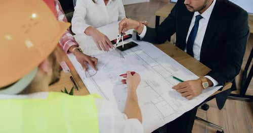 Team of Architects and Engineers Discuss Building Plans