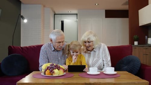 Child With Grandparents Using Tablet at Home