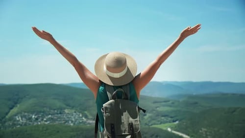 Active Woman Raising Hands on Top of Mountain Enjoying Freedom