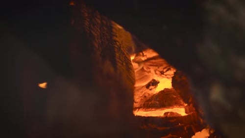 Glowing Embers and Flames in Dark Fireplace