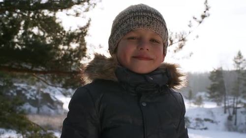 Smiling Boy in Winter Landscape With Snowy Background