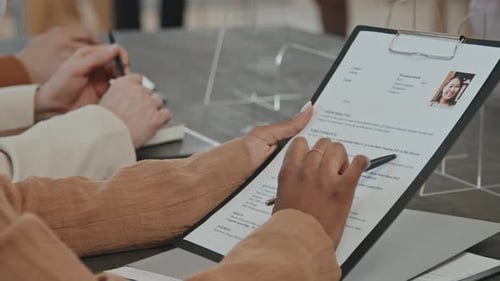 Reviewing Resumes During a Business Meeting