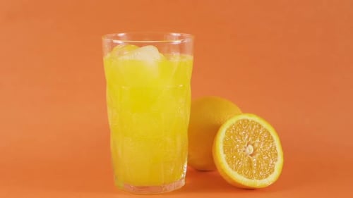 Refreshing Orange Juice with Ice and Straw