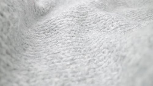 Extreme detail view of sheep wool cloth texture flowing in macro dolly shot.