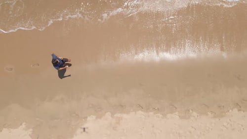 Foto
aérea a cámara lenta de un joven corriendo en una hermosa playa. Concepto de estilo de vida saludable y