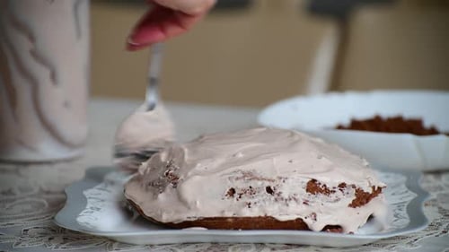 Woman Frosting Two Layer Chocolate Cake at Home