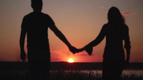 Silhouetten eines jungen Paares bei Sonnenuntergang